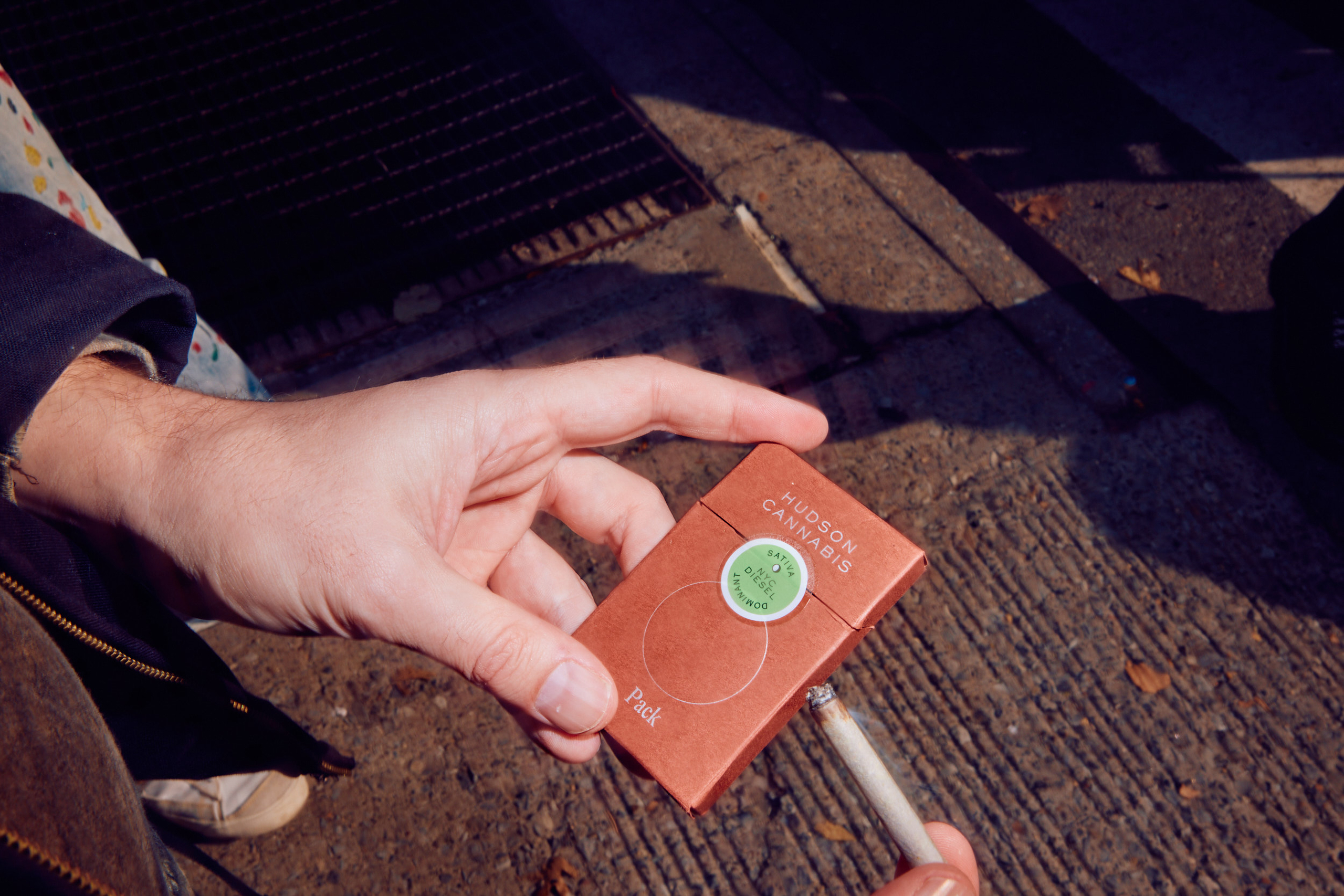 Packaging in use: preroll, pack, lighter on a city sidewalk